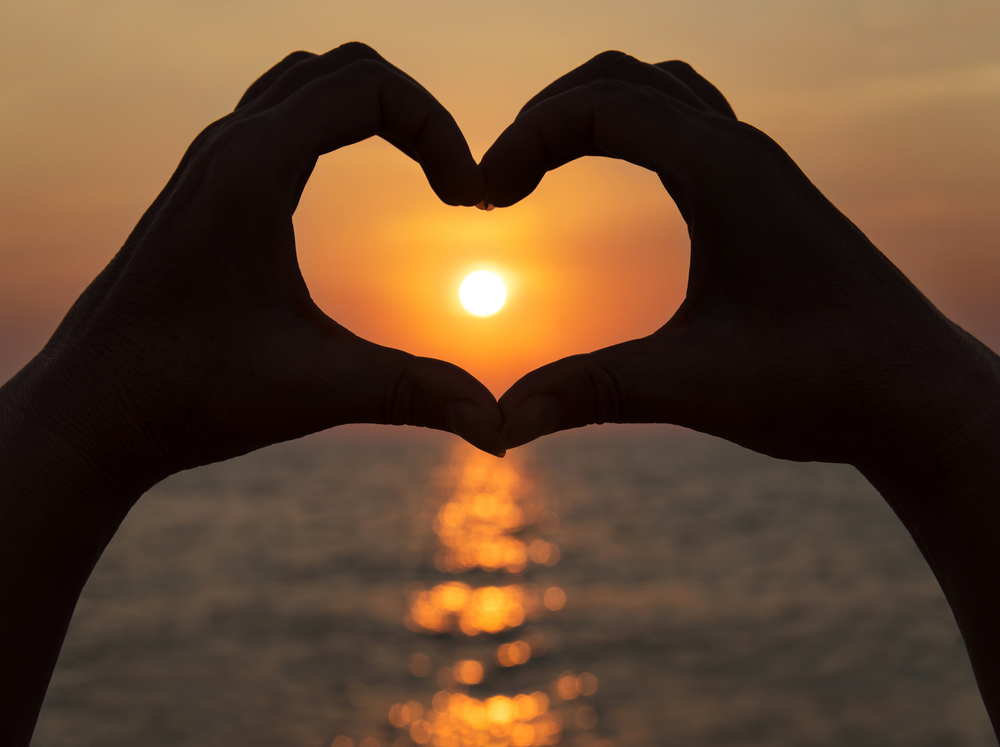 Permalink to 10 getaways to love Valentine’s Day again Valentine's Day: Hands make a heart shape against a setting sun © EMprize
