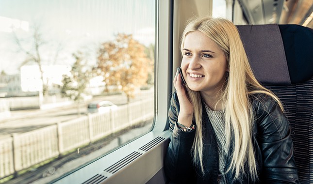 Cheap train travel: A young woman travelling by train © oneinchpunch