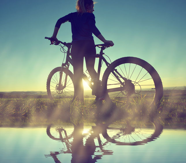 Lady on a bicycle in the sunset