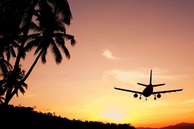Flying on a budget: An airplane flying into the sunset © Happy Stock Photo