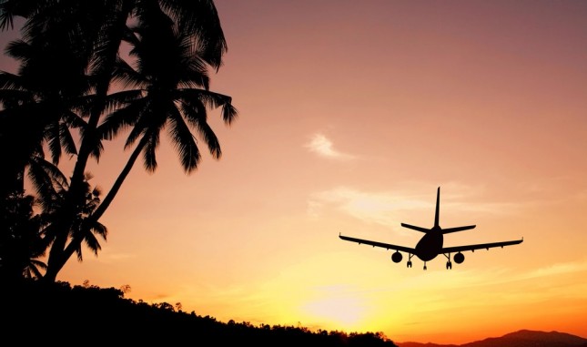 Flying on a budget: An airplane flying into the sunset © Happy Stock Photo