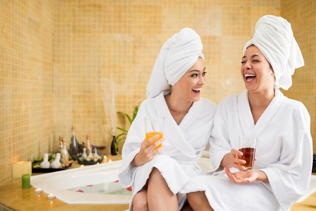 At spa break two women in robes laughing