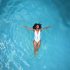 Woman floating in blue water