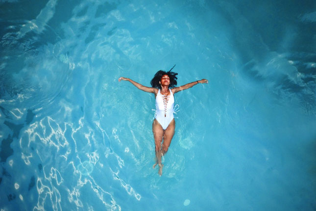 Woman floating in blue water